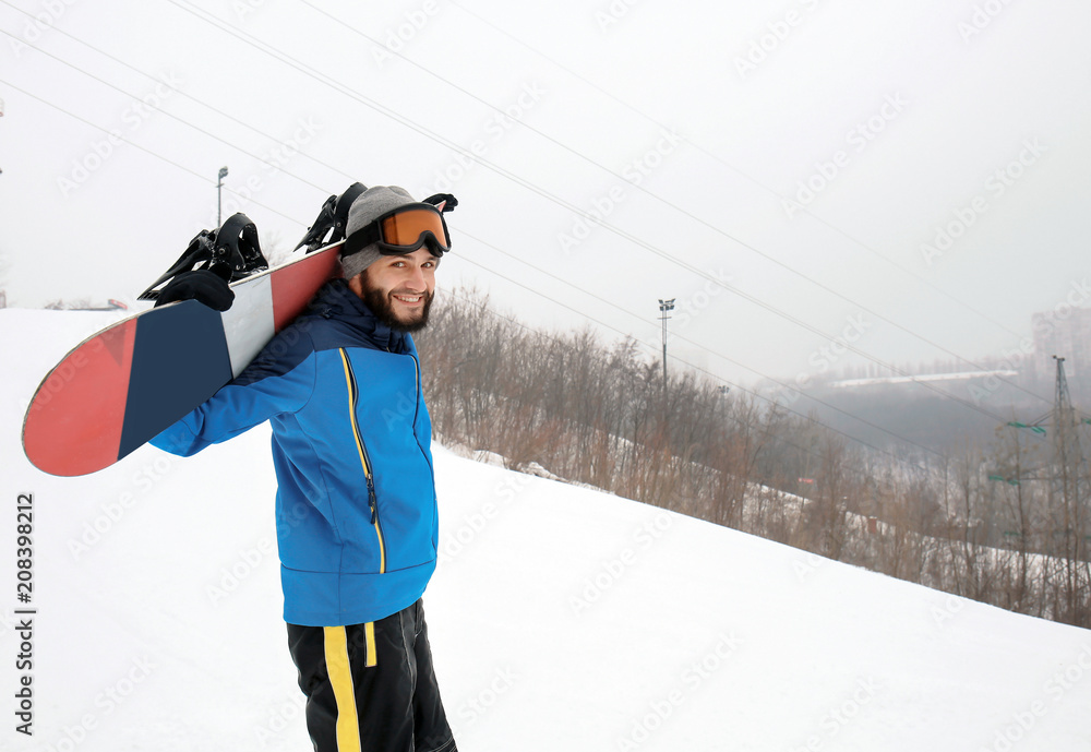 冬季度假区斜坡上的男单板滑雪运动员