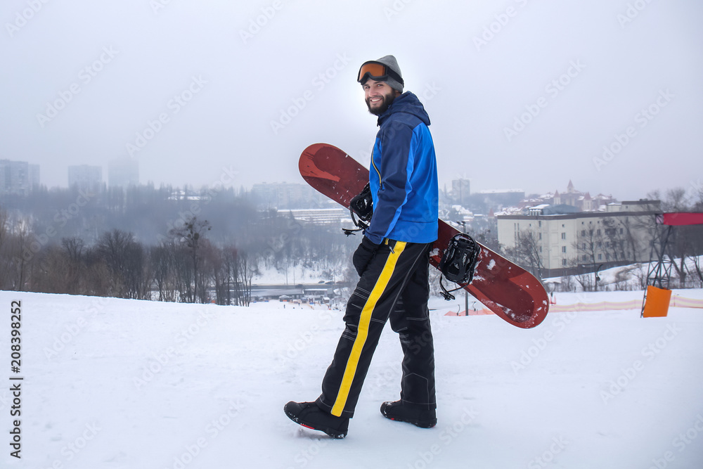 冬季度假胜地斜坡上的男单板滑雪运动员