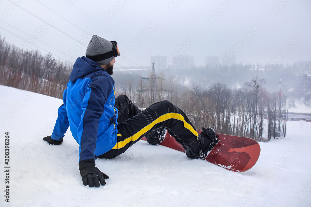 冬季度假胜地斜坡上的男单板滑雪运动员