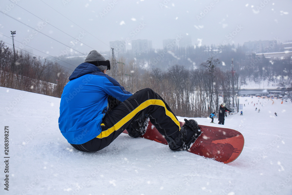 冬季度假区斜坡上的男单板滑雪运动员