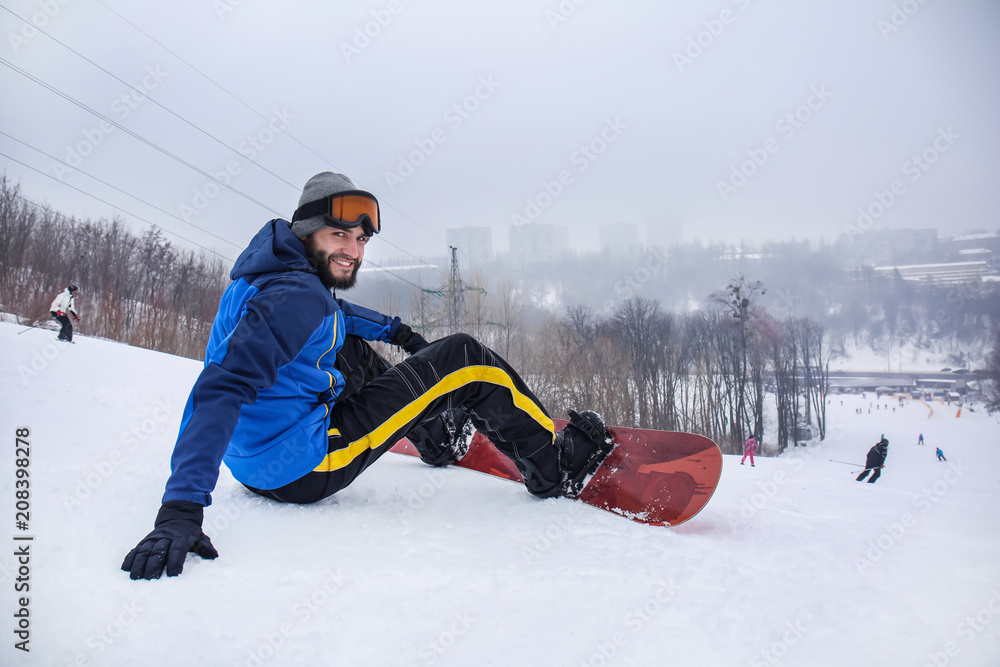 冬季度假胜地斜坡上的男单板滑雪运动员