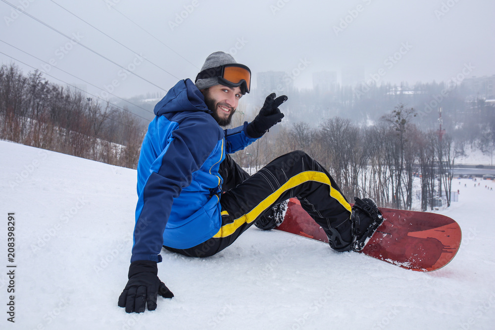 冬季度假胜地斜坡上的男单板滑雪运动员