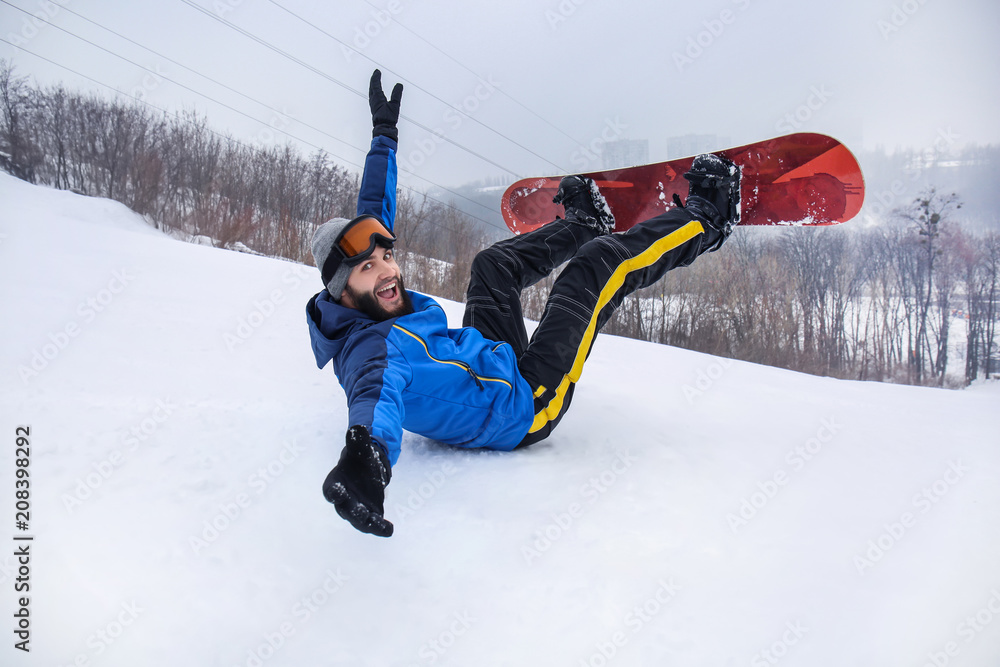 冬季度假区斜坡上的男单板滑雪运动员