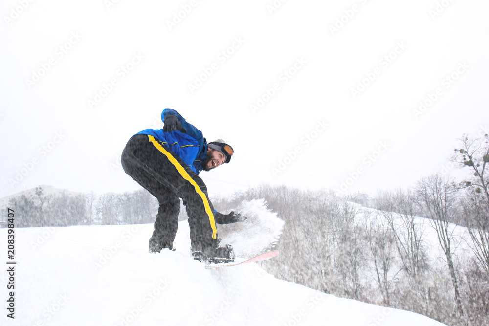 冬季度假胜地斜坡上的男单板滑雪运动员