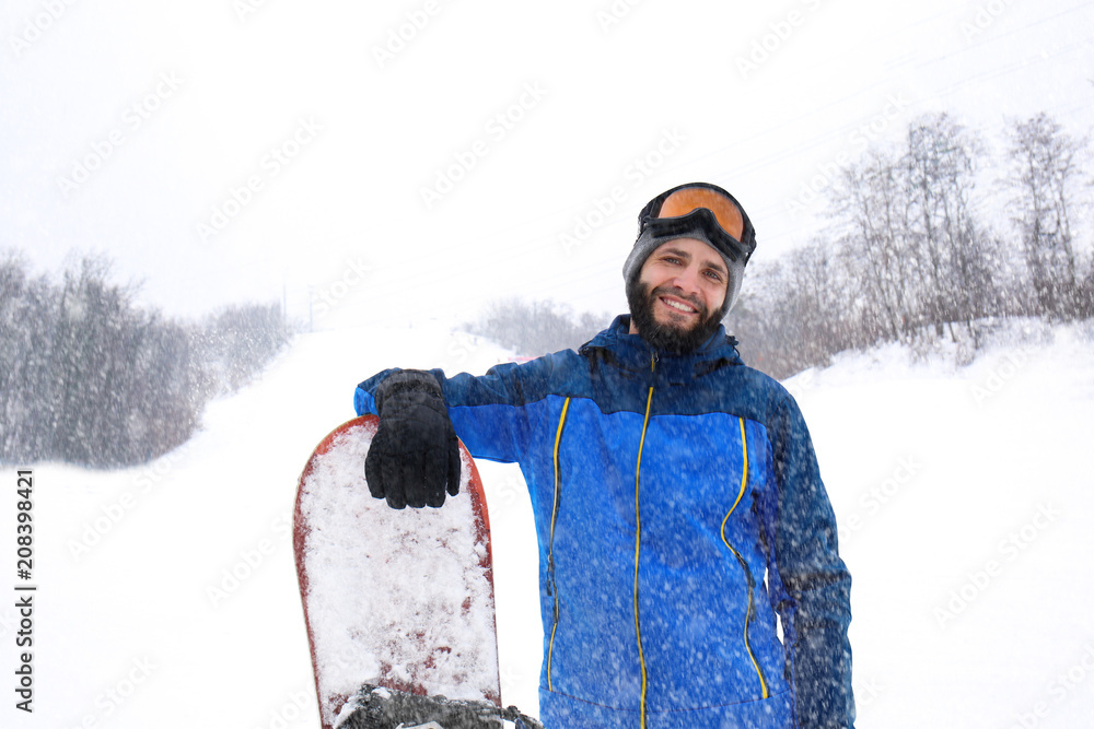 冬季度假胜地斜坡上的男子单板滑雪运动员