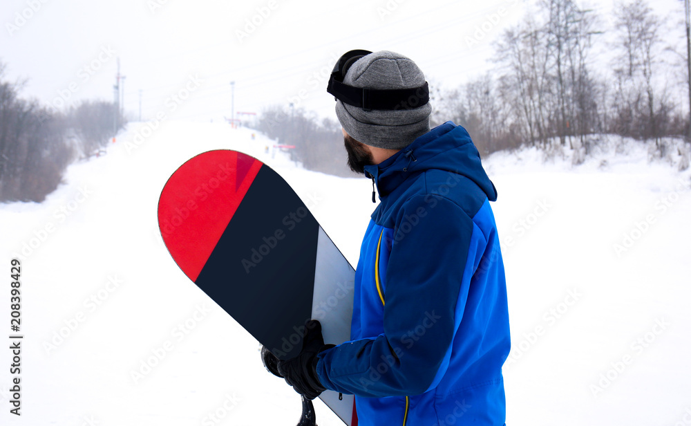 冬季度假胜地斜坡上的男单板滑雪运动员