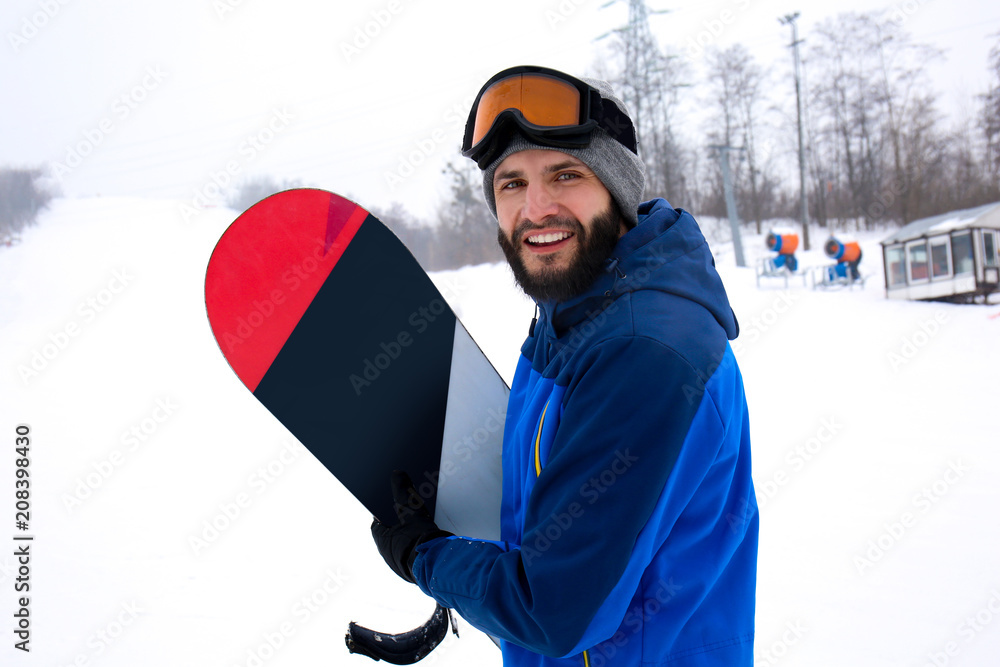 冬季度假区斜坡上的男单板滑雪运动员