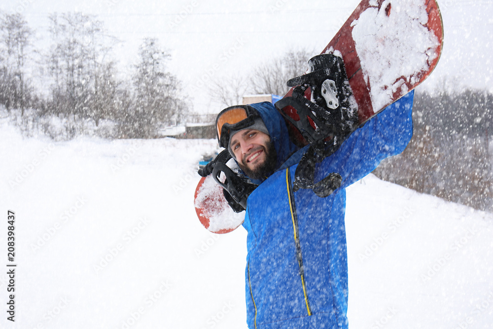 冬季度假胜地斜坡上的男单板滑雪运动员