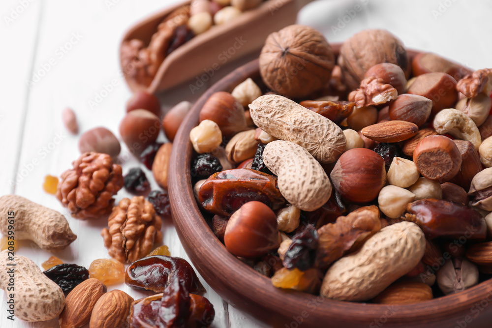 Plate with different nuts and dried fruits on table, closeup