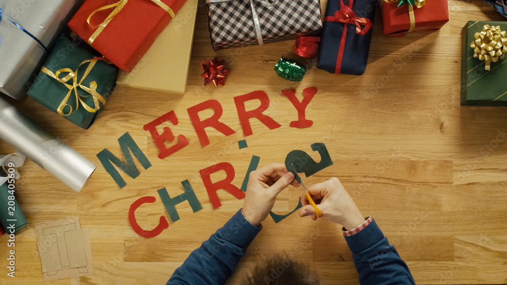 Top View of a Man Cutting Letters for Words Merry Christmas