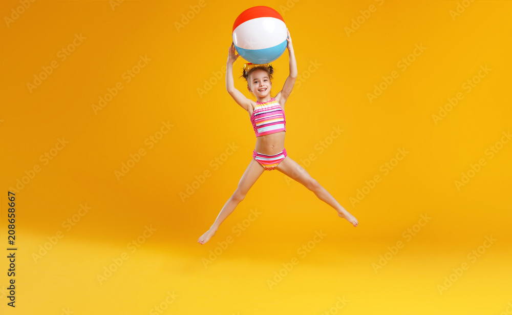 funny happy child  jumping in swimsuit    on colored background