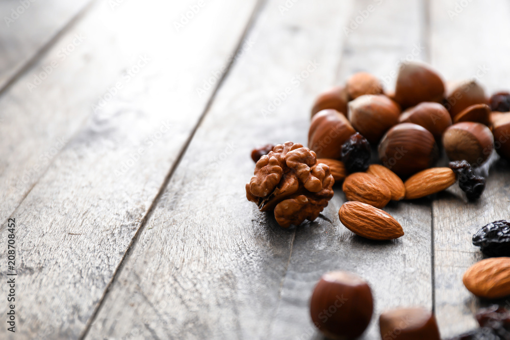 Various tasty nuts and dried fruits on wooden table