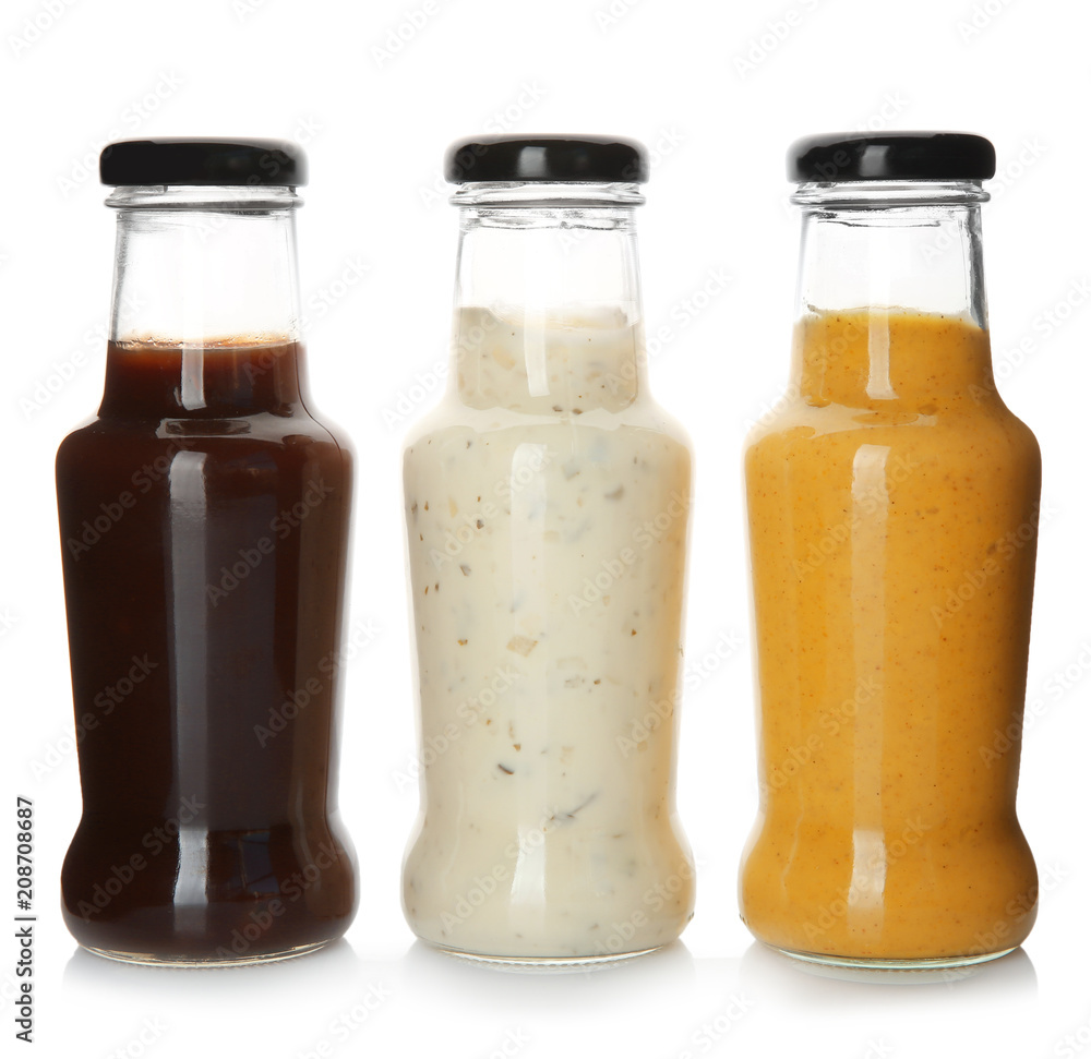 Bottles with tasty sauces on white background