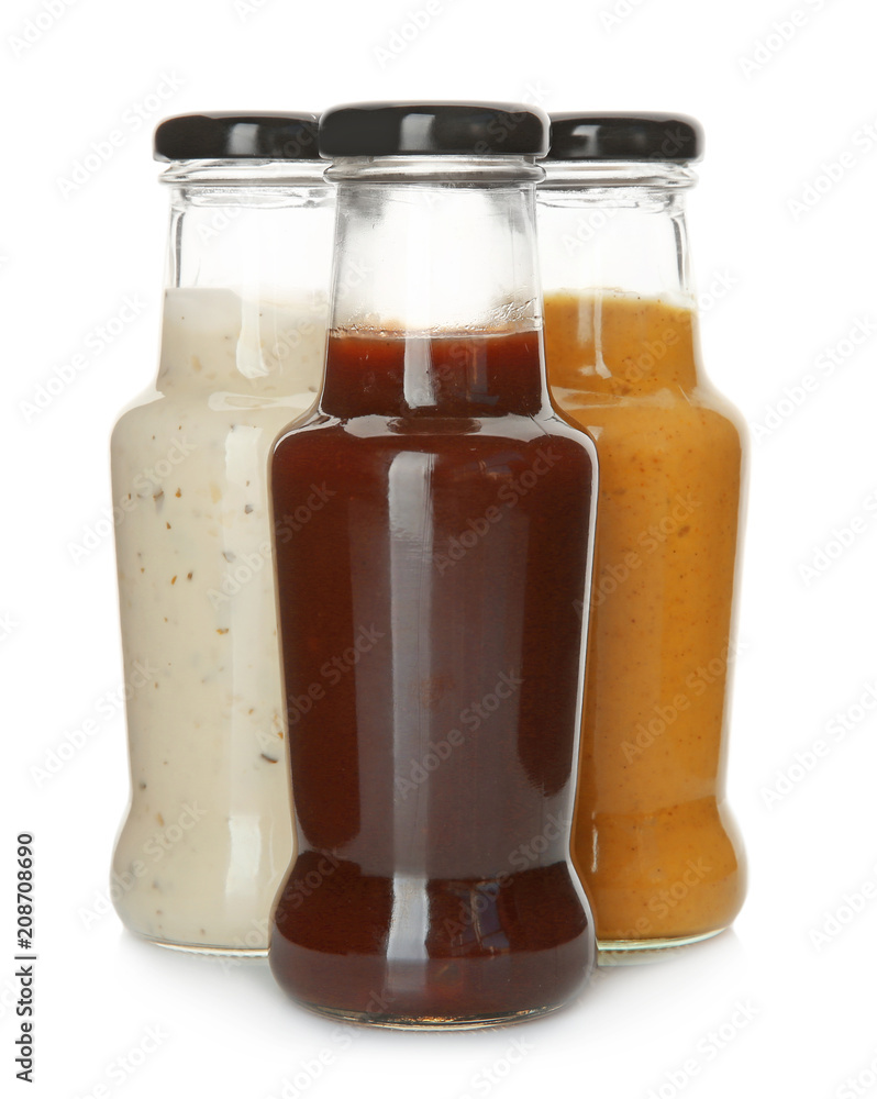 Bottles with tasty sauces on white background