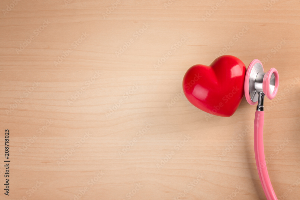 Stethoscope with small heart on wooden background