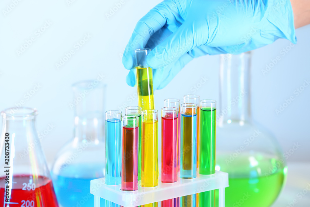 Laboratory worker taking test tube from rack, closeup