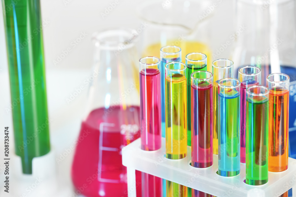 Test tubes with colorful liquids in rack, closeup