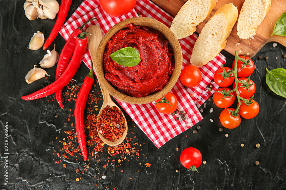 Bowl with red sauce and vegetables on table, top view