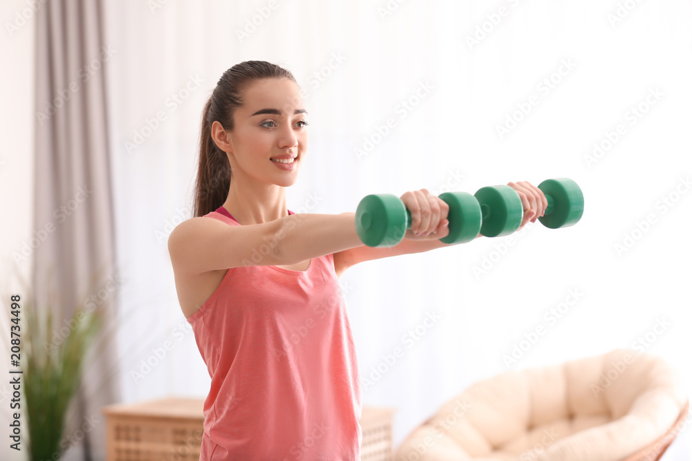 Beautiful young woman doing exercises in morning