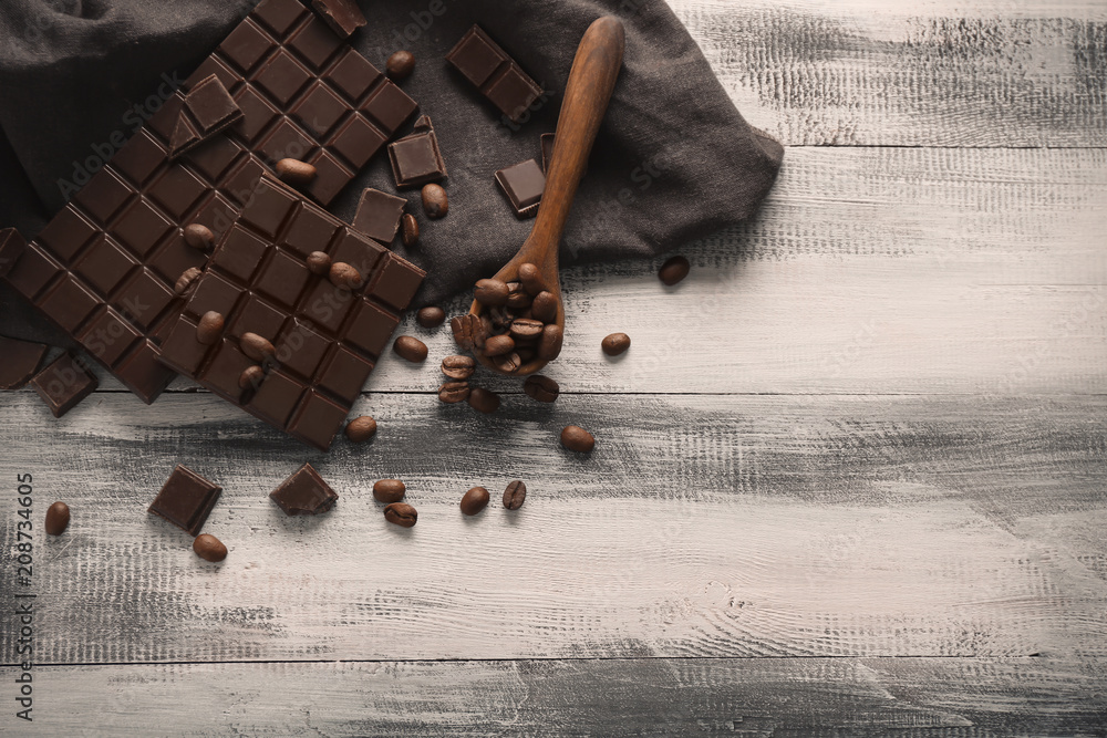 Flat lay composition with dark chocolate and coffee beans on table