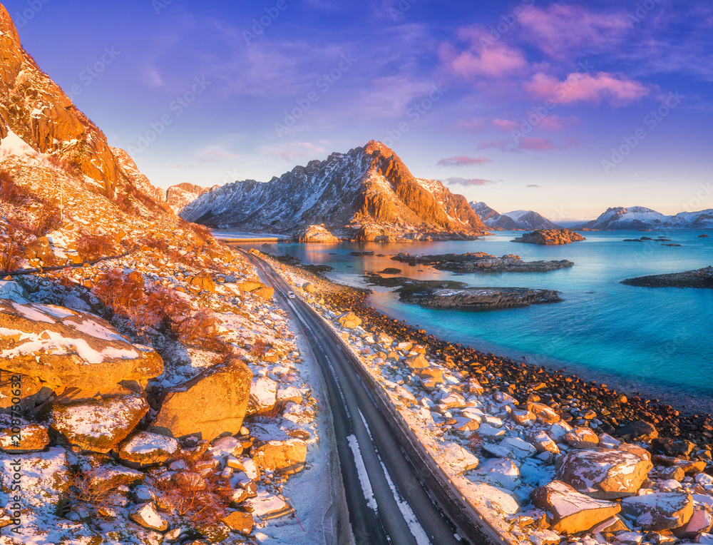 Aerial view of beautiful mountain road near the sea, mountains, purple sky at sunset in Lofoten isla