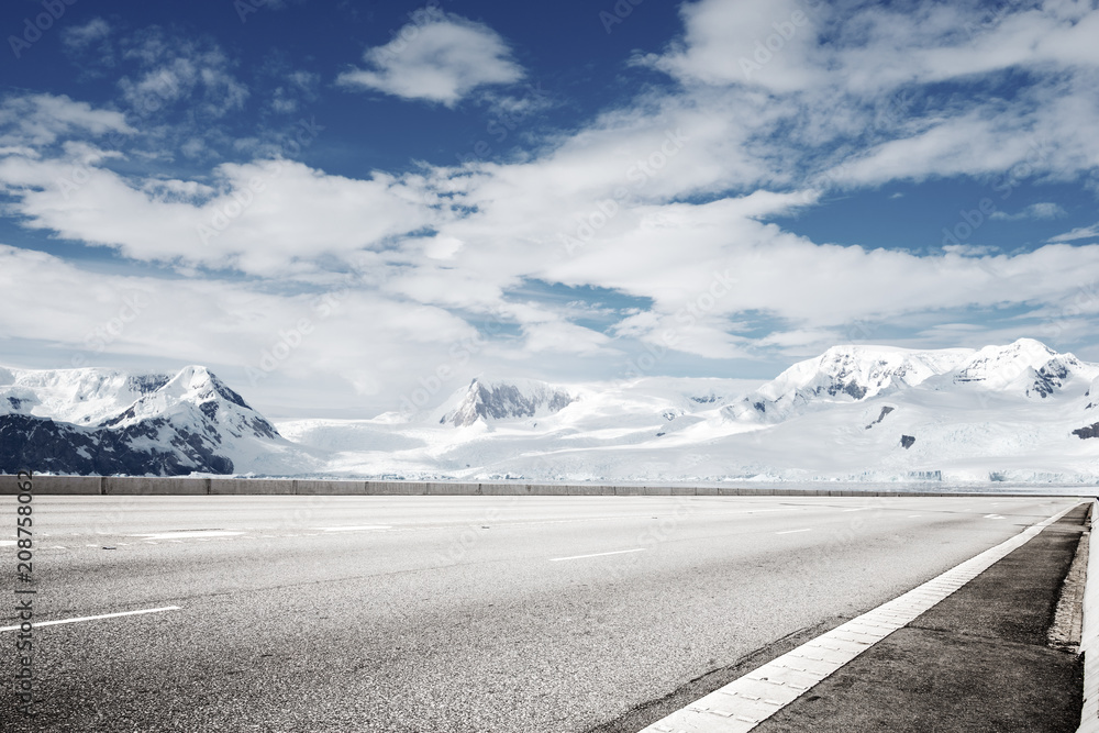 empty asphalt road with snow mountain