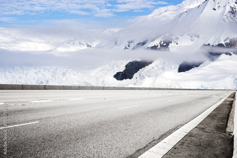 empty asphalt road with snow mountain