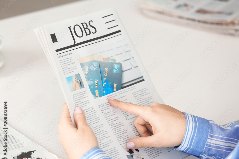 Woman reading morning newspaper indoors