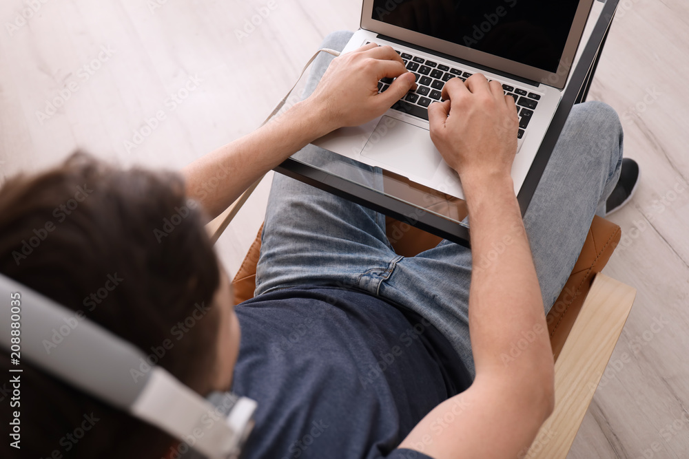 Freelancer with headphones using laptop at home