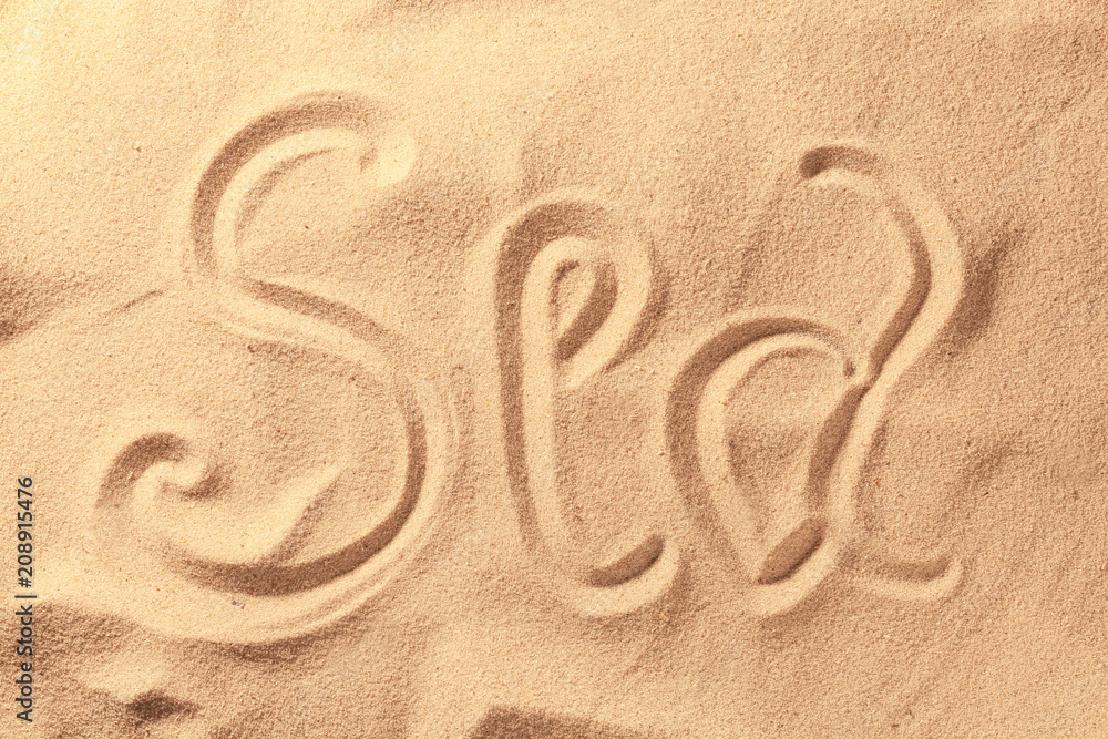 Word SEA written on beach sand