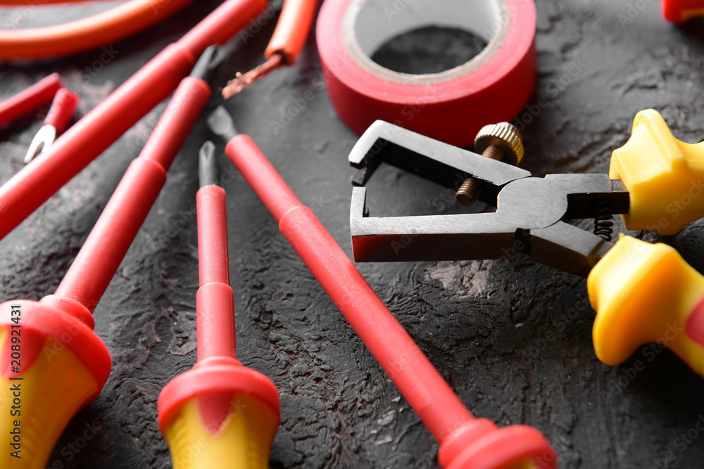 Different electricians supplies on grey background, closeup