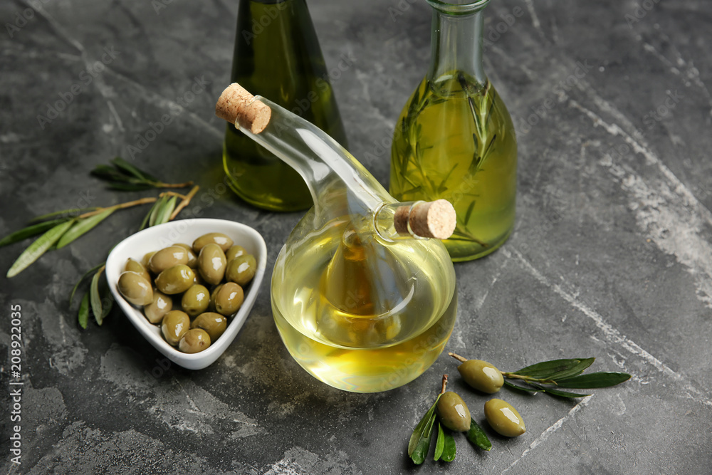 Glassware with oil and olives on table