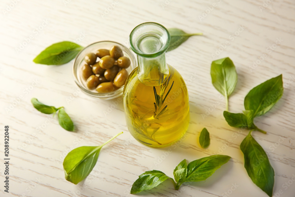 Bottle with oil and olives on wooden table