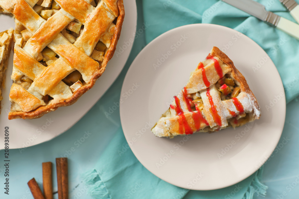 Plate and board with tasty homemade apple pie on table