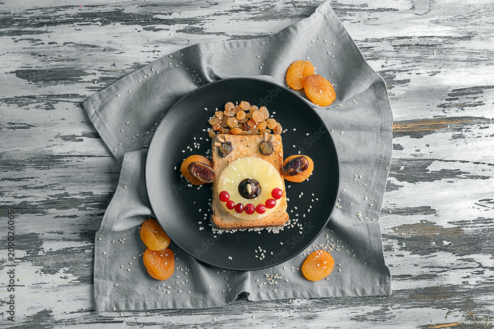 Plate with creative toast for child on wooden table