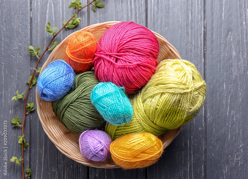 Basket with knitting yarn on wooden table