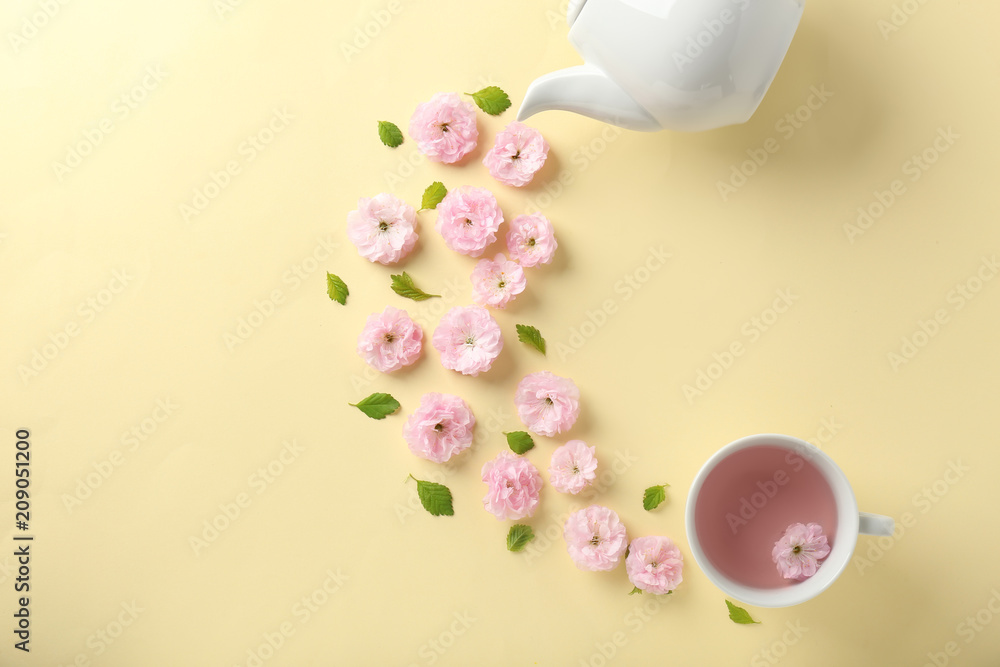 Composition with cup and blossoming flowers on color background