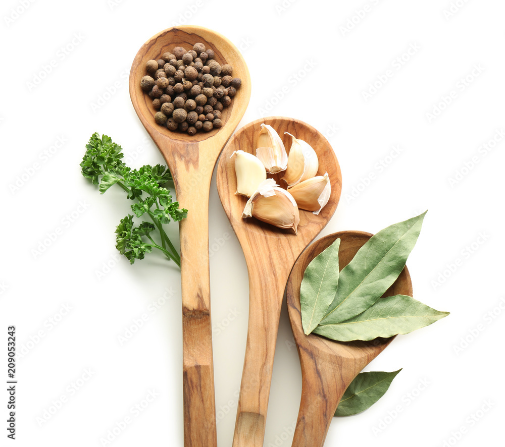 Wooden spoons with various spices on white background