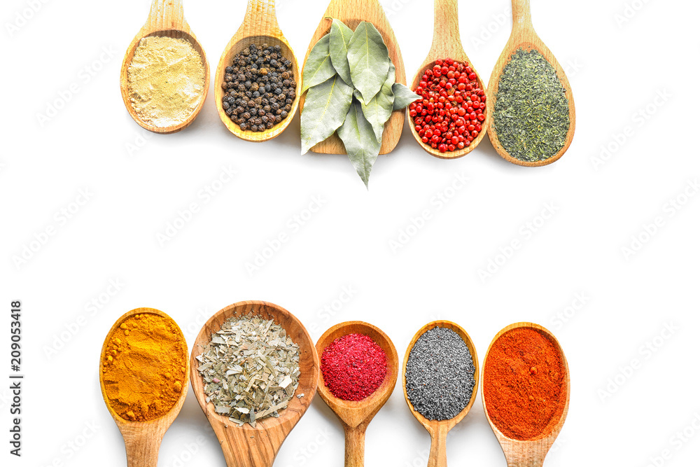 Wooden spoons with various spices on white background