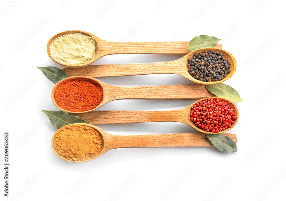 Wooden spoons with various spices on white background