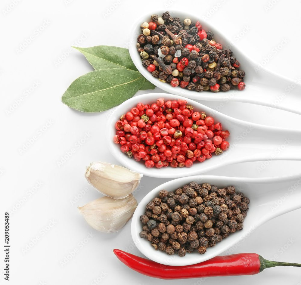 Spoons with various spices on white background