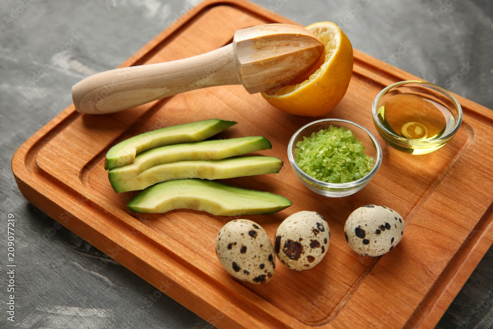 Avocado with ingredients for natural homemade cosmetics on wooden board