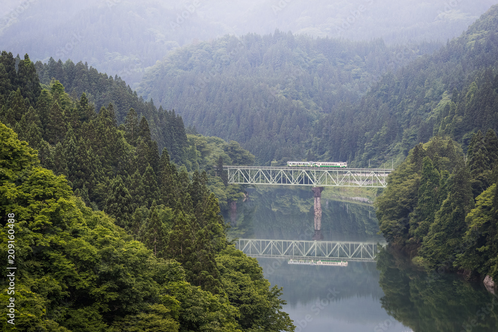 Fukushima , JAPAN - June 19 : The local train Tadami line and Tadami river on June 18 , 2017 in Fuku