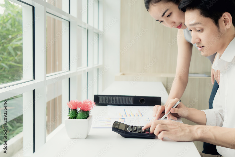 Asian business couple working together on project at modern startup office. Senior business woman su