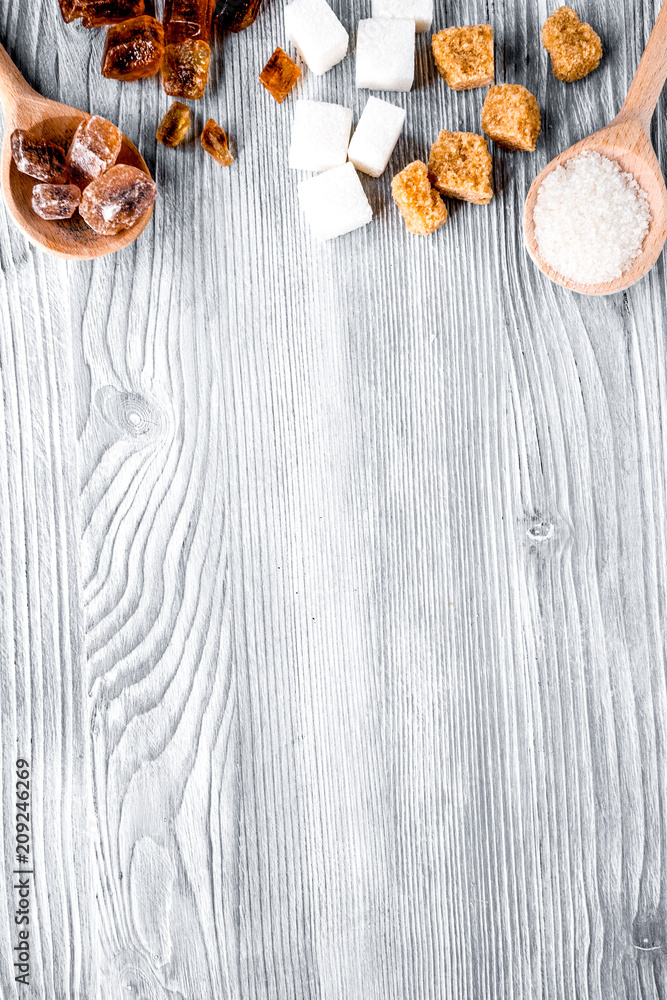 lumps of sugar with spoons sweet set on gray table background to