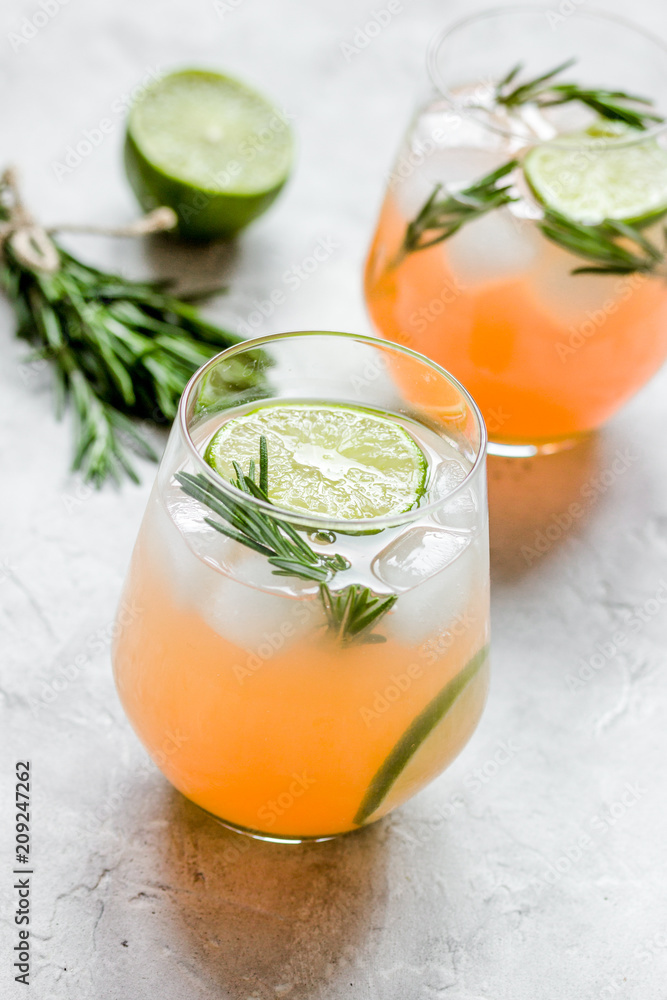 fitness cocktail in glass with lime and rosemary on stone table 