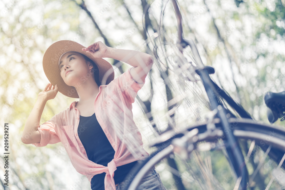 亚洲女性在森林中骑着vntage自行车旅行理念