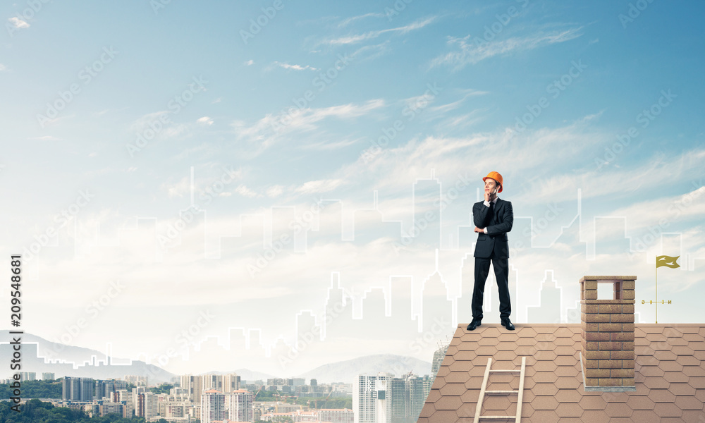 Engineer man standing on roof and looking away. Mixed media