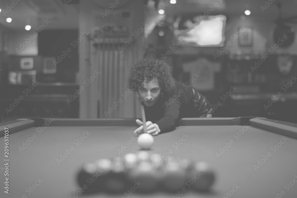 Woman playing pool at a bar