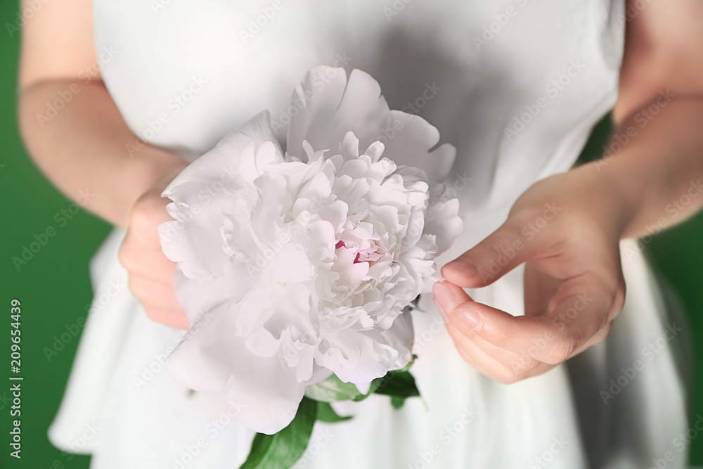 Young woman holding beautiful peony, closeup